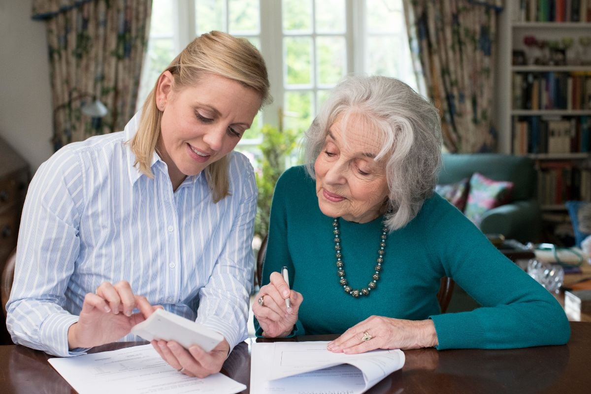 senior and adult daughter reviewing a long term care policy together