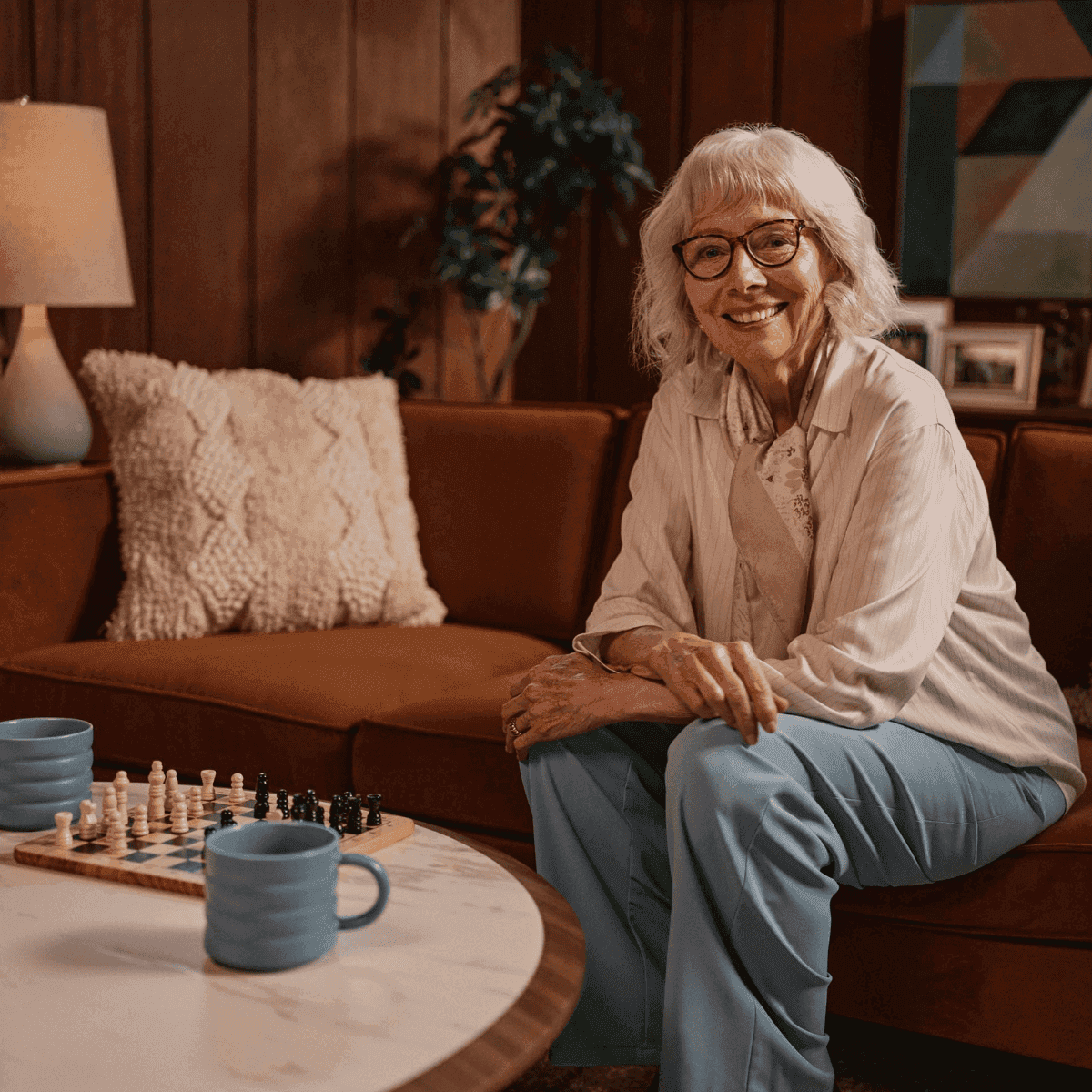 Older adult woman smiling as she plays chess to keep her mind active and engaged