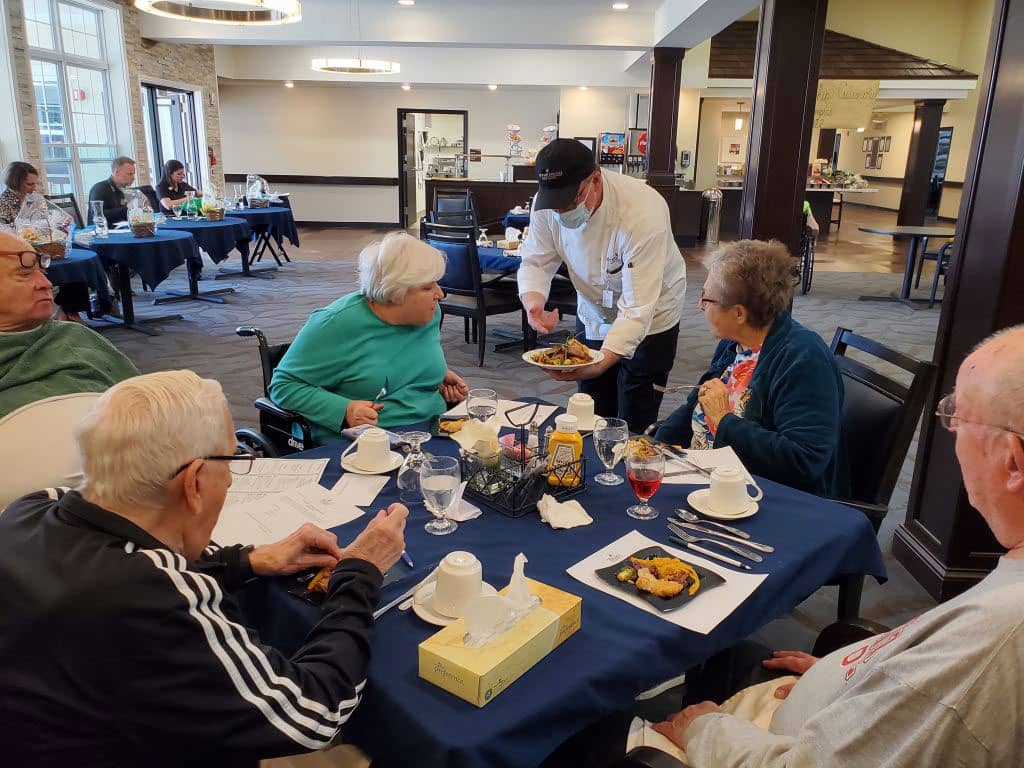 Chef serving food to seniors