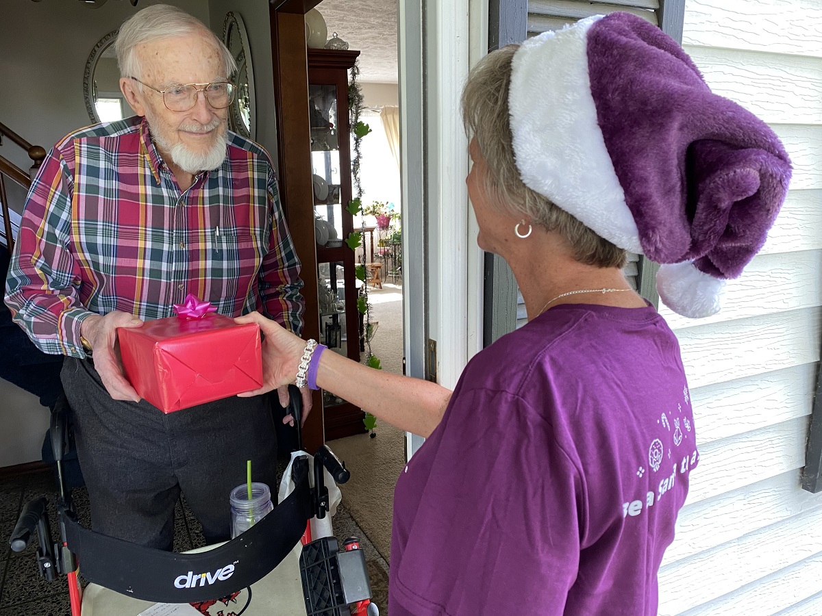 Caregiver delivering gift to senior