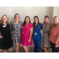 group of 6 smiling ladies celebrating Wildcat Senior Living Grand Opening