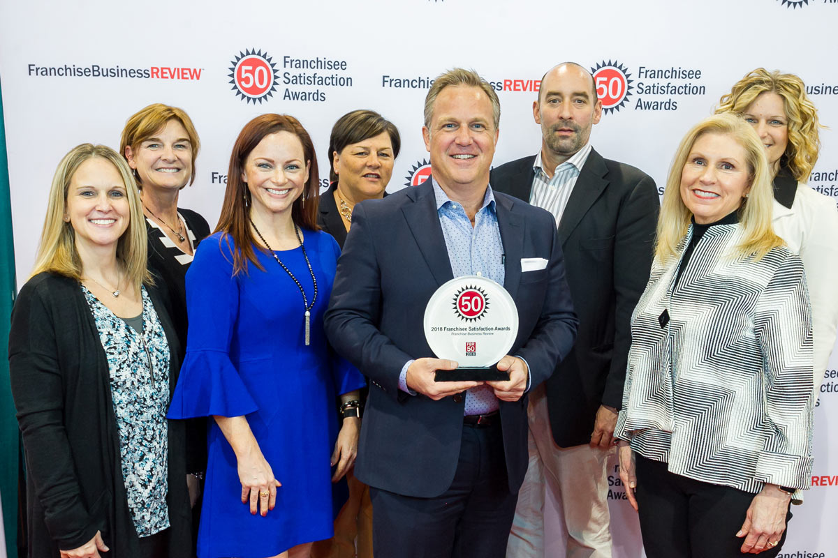 Home Instead leaders holding Franchise Business review award