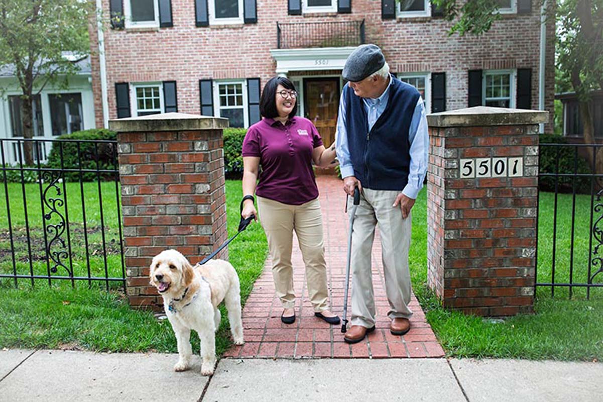 A caregiver and  senior walking outside to promote an active lifestyle