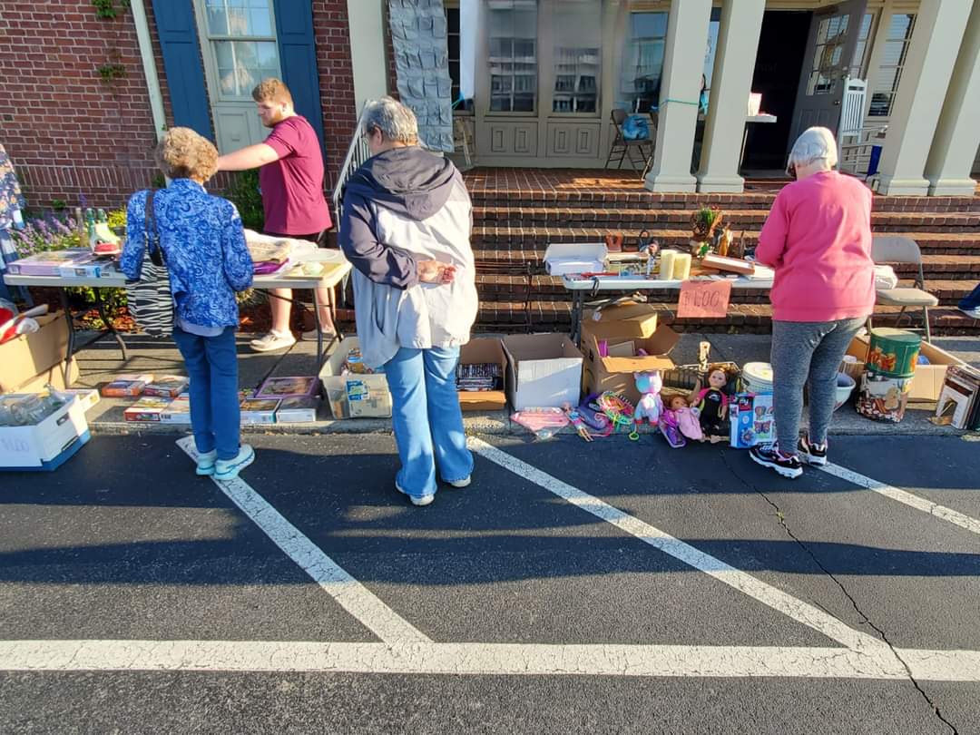 Photo of a Home Instead Care Professional showing some members of the Maryville, TN senior community items for sale at the