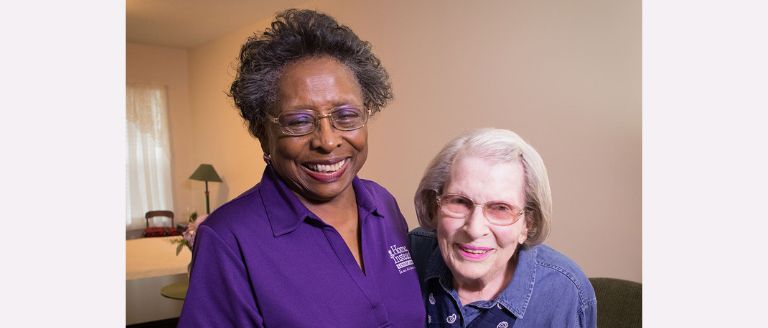smiling home instead caregiver standing with a senior
