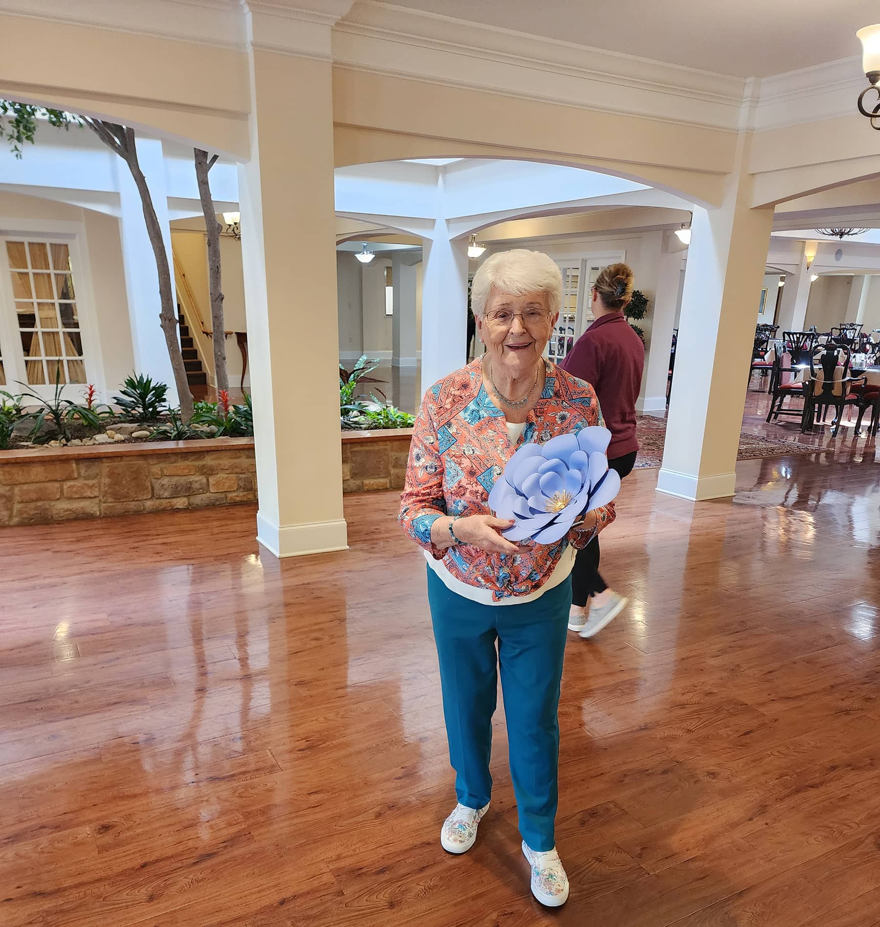 Photo of a Parkview Senior Living resident holding her paper wall flower