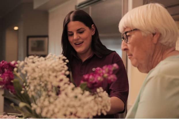 Care Pro and Senior looking at Flowers in the kitchen (1).jpg