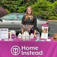 home instead team member at booth at rufty homes senior health and fitness day