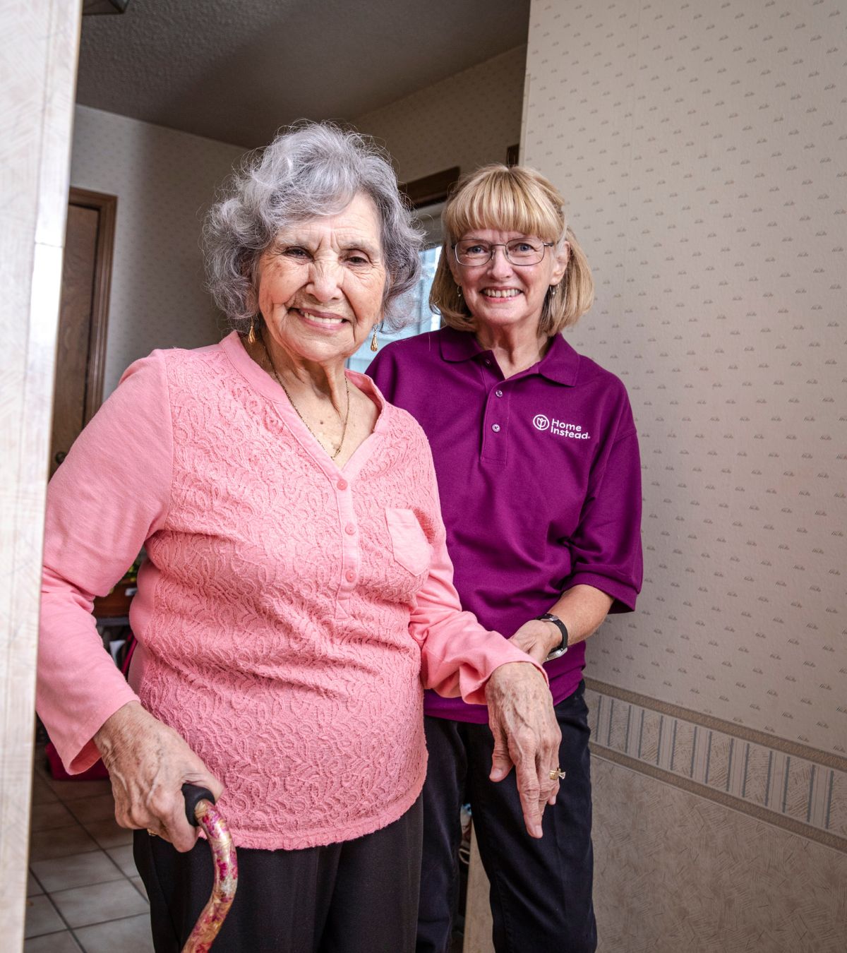 home instead caregiver assisting senior client on a cane