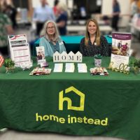 home instead team members at booth at rufty homes senior health and fitness day