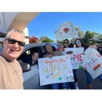 home care team holding signs featuring the caregiver pie drive