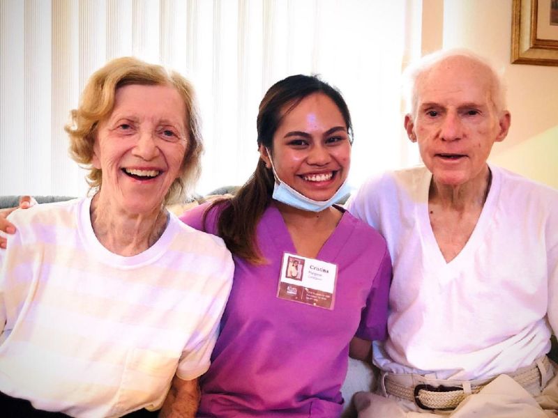 a home instead palm desert caregiver smiling with two seniors