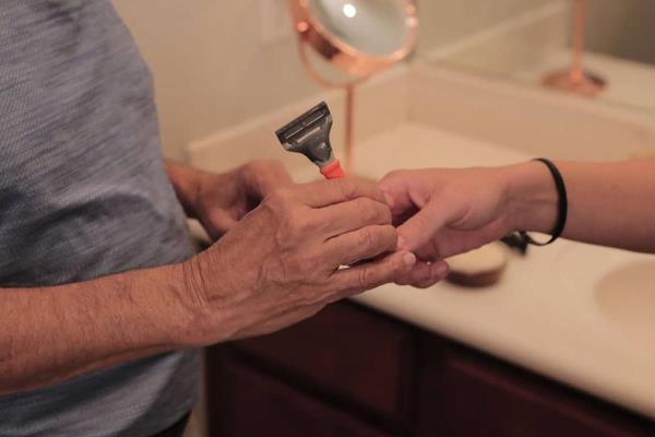 Care Pro handing a senior a razor