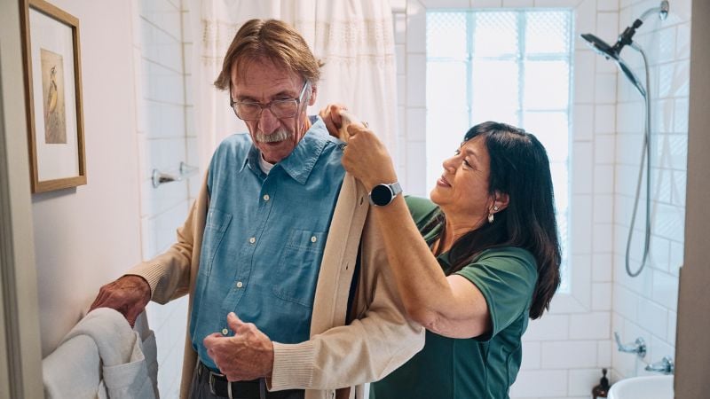 Home Instead caregiver supports senior client with getting dressed in North Dayton, OH