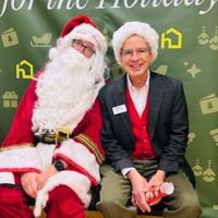 home instead team member posing for photo with santa