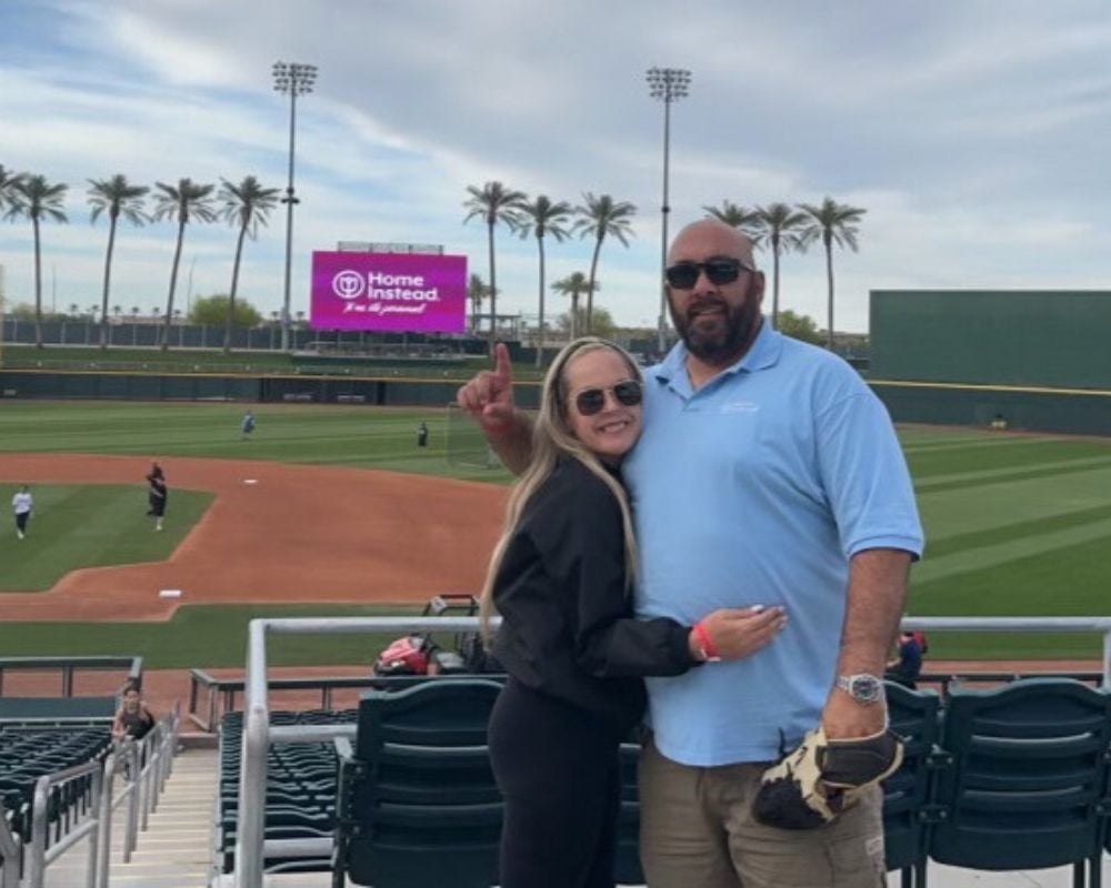 Home Instead Goodyear, AZ Owners at Baseball Game with Home Instead sign in background
