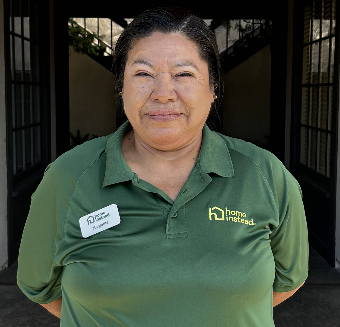 Margarita Arreola in her Home Instead uniform smiling warmly outside the office
