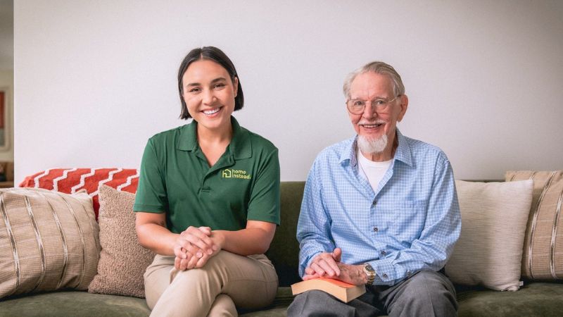 home instead caregiver sitting with senior client