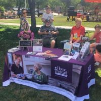 home instead booth at ice cream social with people sitting around in lawnchairs