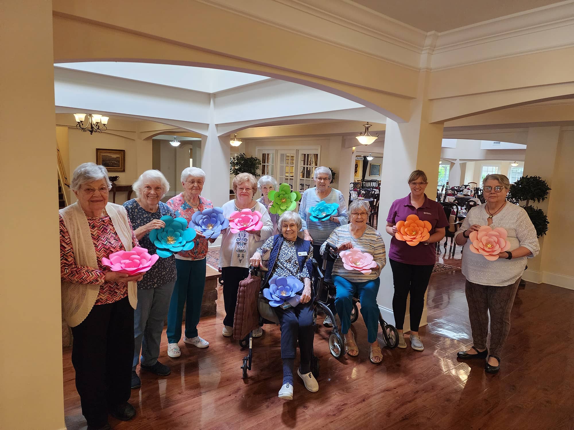 Photo of the Parkview Senior Living residents and our Home Instead team member holding their paper wall flowers