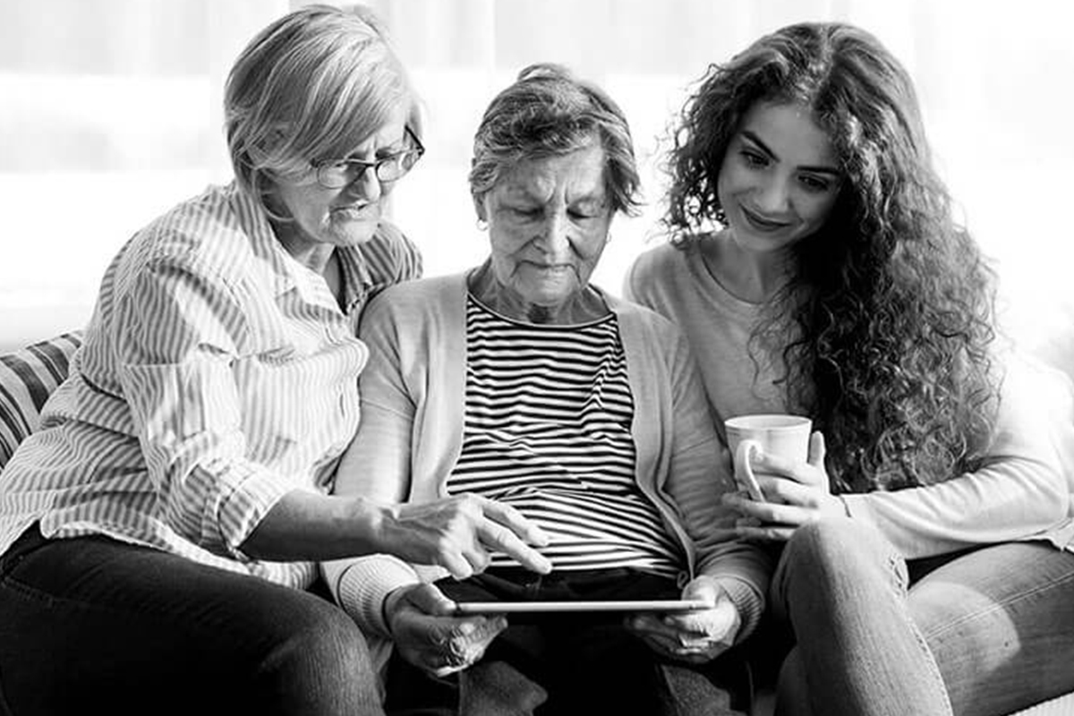Mother and daughter helping Grandmother with tablet