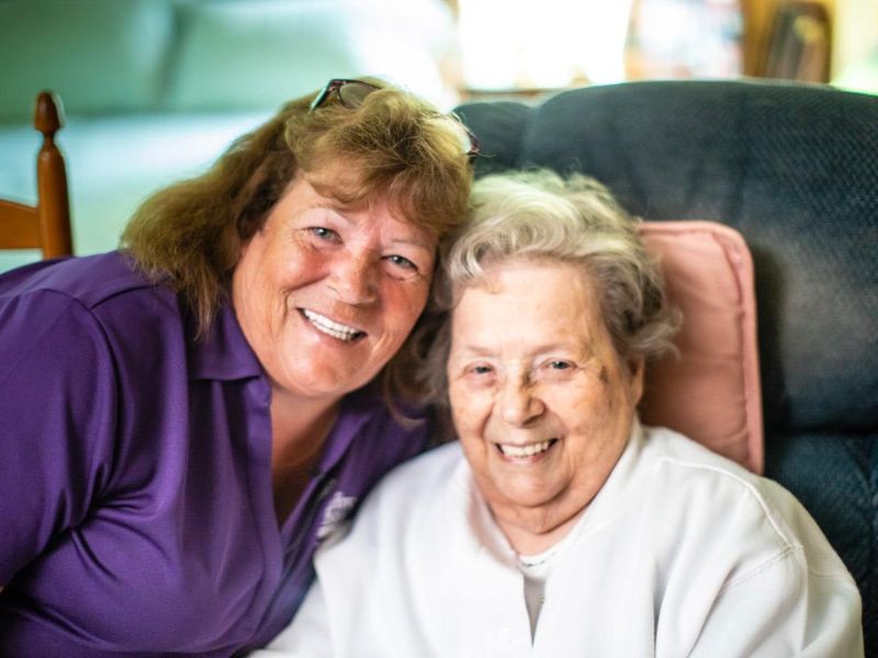 smiling home instead caregiver and senior  sitting together