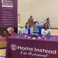 cleveland home instead team members behind booth at job fair