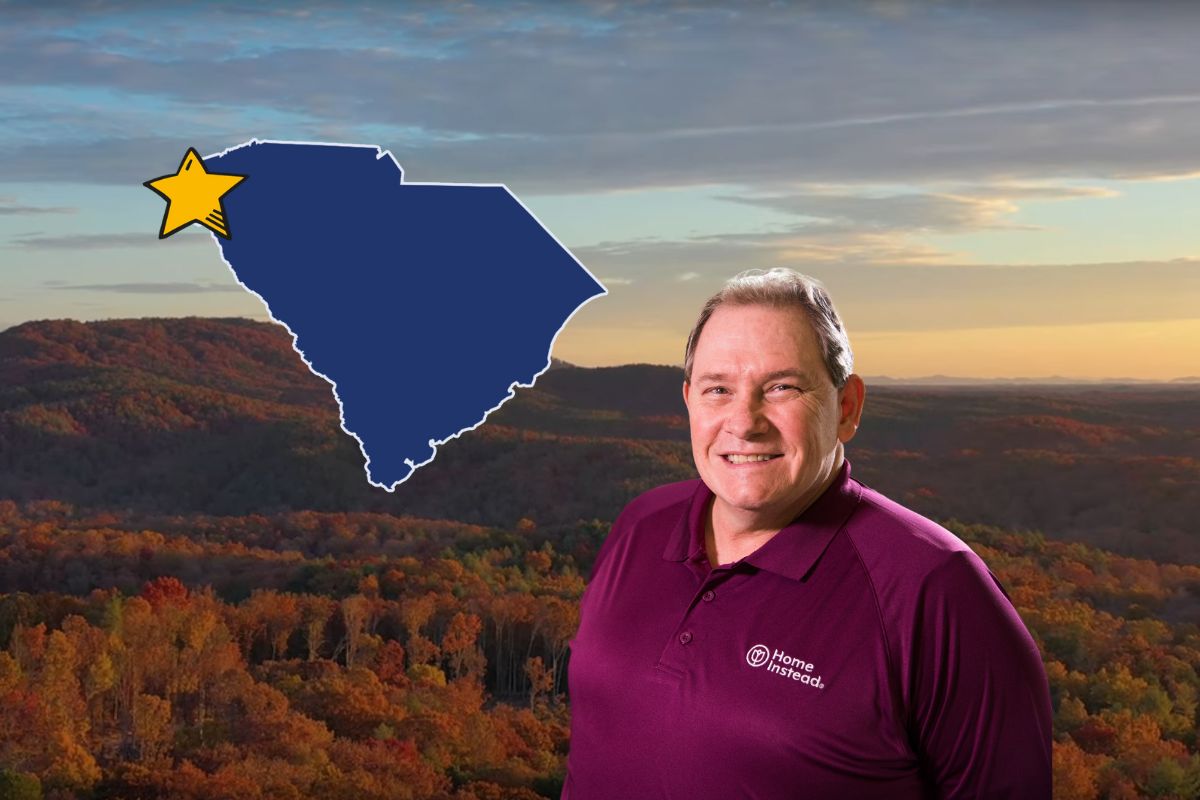 Home Instead caregiver standing with Oconee County, SC in the background