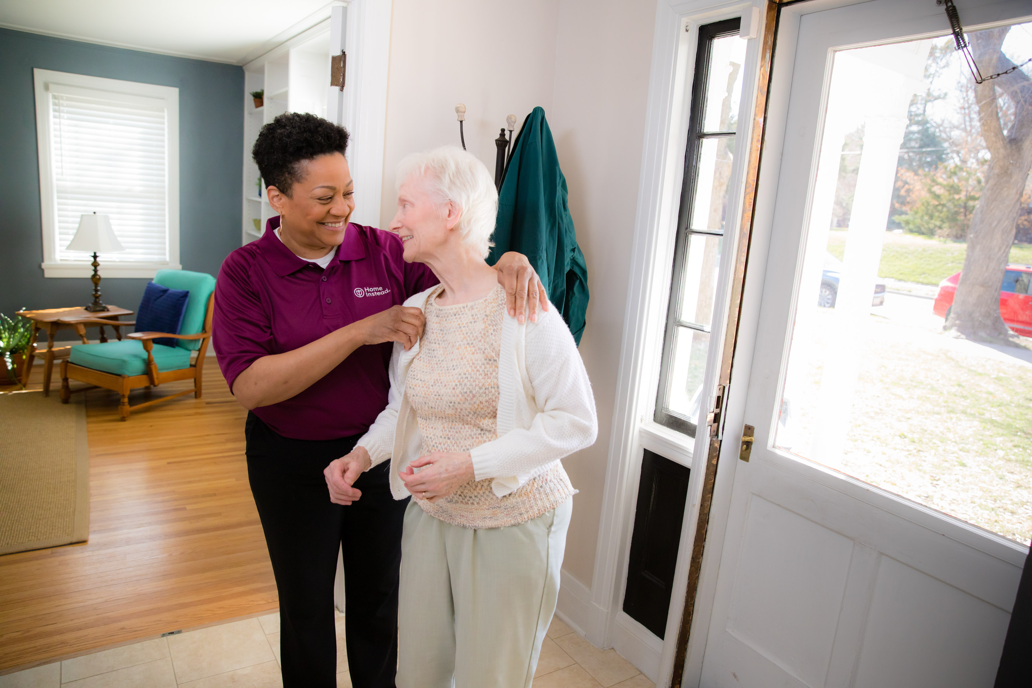 Home Instead Caregiver helping Client put on sweater