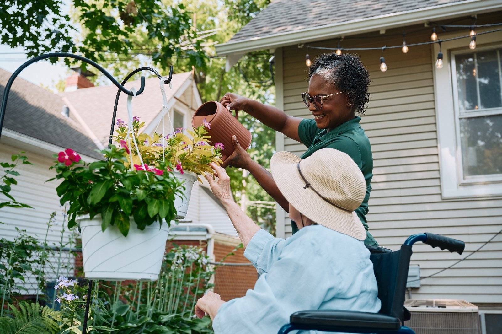 Home Instead Caregiver and aging woman talking and smiling at a table.