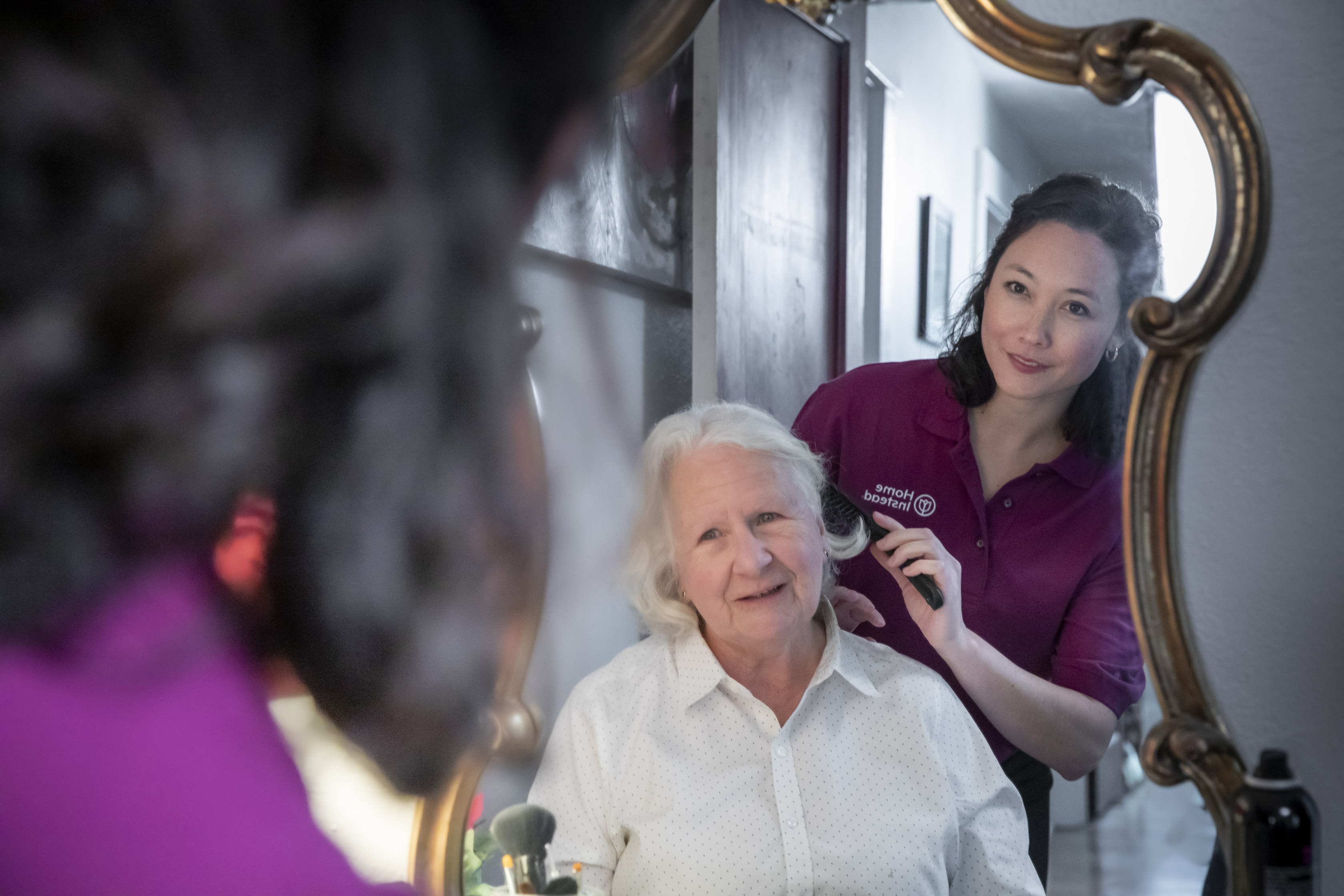 Home Instead Caregiver helping client with grooming