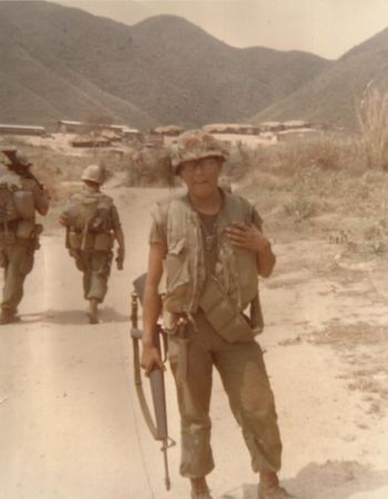 old photo of a soldier standing in a dirt road