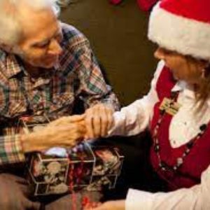 senior receiving a christmas gift from a volunteer