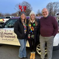home instead team at parade in wrapped car