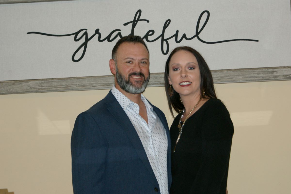 Jason and Acacia under grateful sign rev