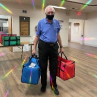 man holds two bags of meals