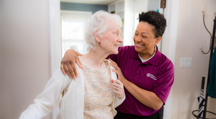Home Instead caregiver steadies standing senior woman