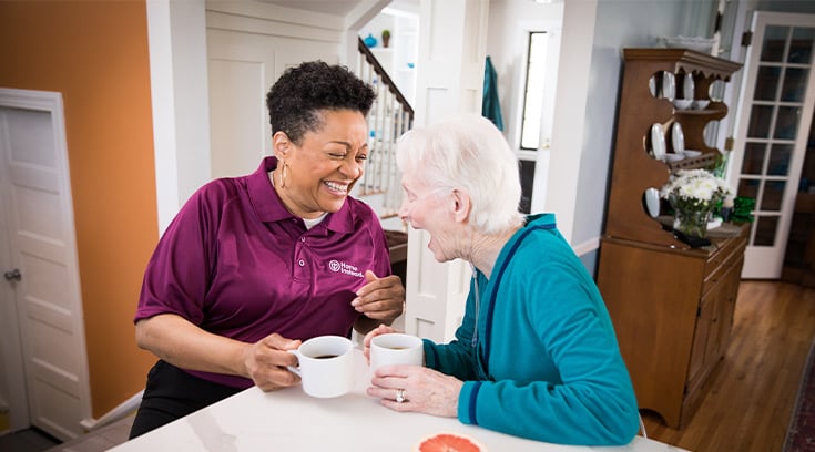 Caregiver and senior enjoying coffee together