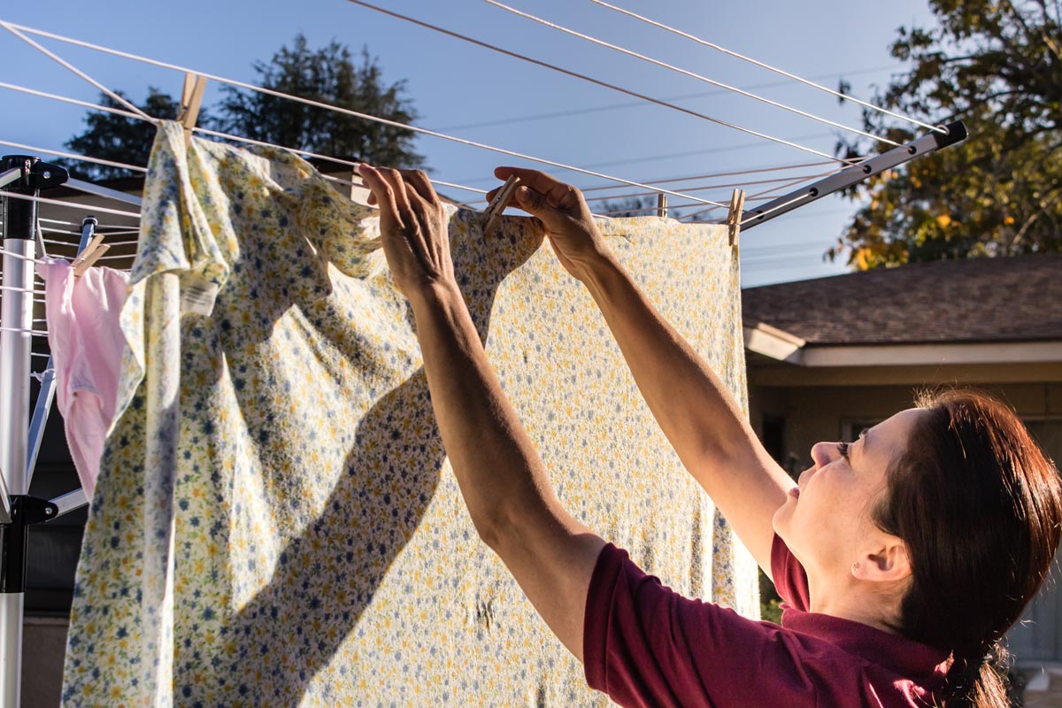 Home Instead Caregiver hanging laundry on clothesline.
