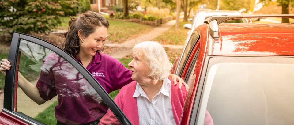 Home Instead Caregiver helps senior woman getting out of car