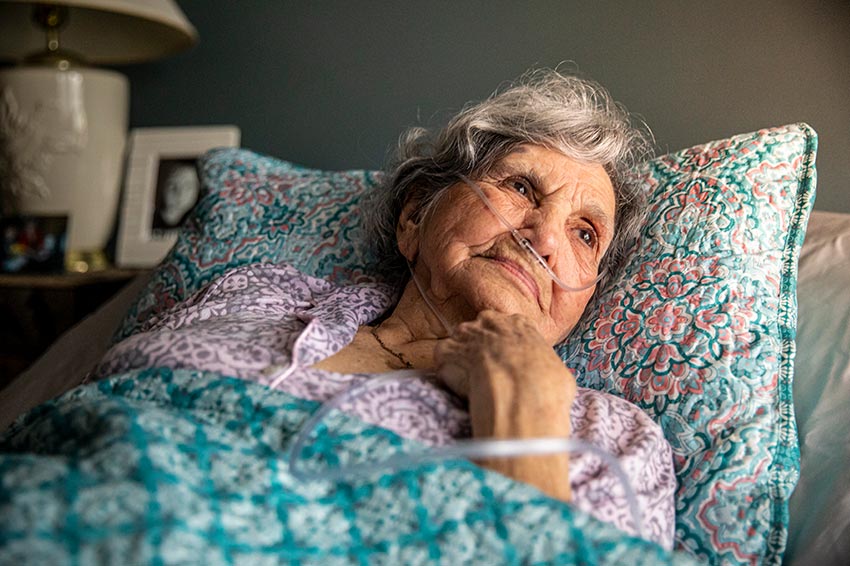 Home Instead CAREGiver senior laying in bed thinking