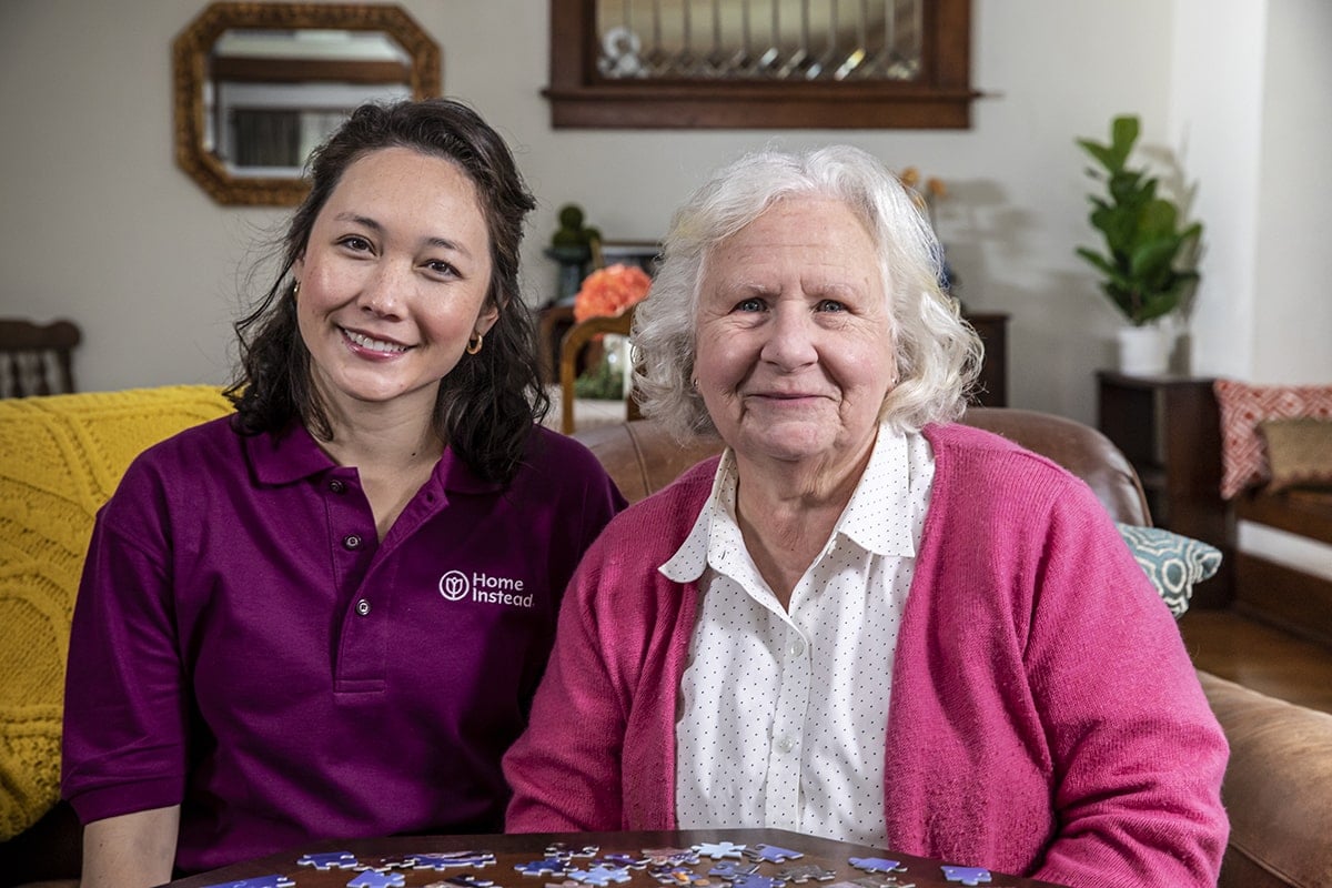 Home Instead Caregiver cares for her senior client while sitting on outside patio.